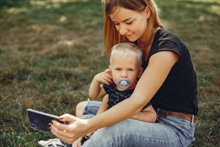 Mother with son playing in a summer parkの写真素材