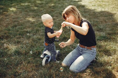 Mother with son playing in a summer parkの写真素材