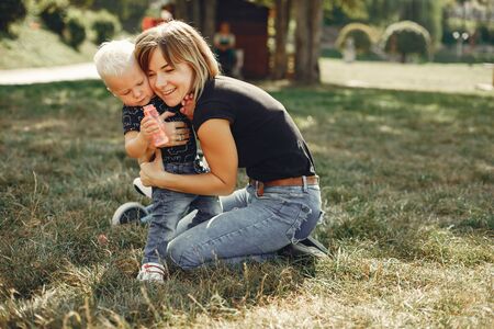 Mother with son playing in a summer parkの写真素材