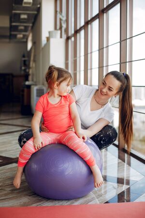 Mother and daughter training in a gymの写真素材