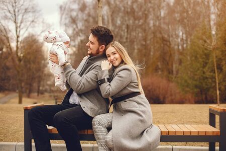 Family with daughter in a autumn parkの写真素材