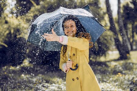 Cute kid plaiyng on a rainy dayの写真素材