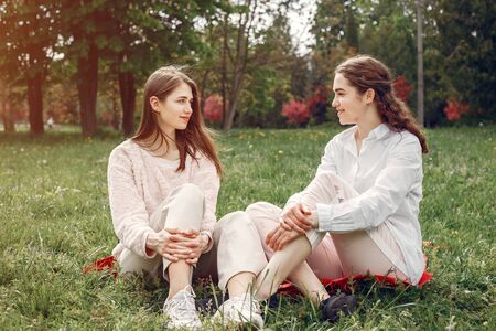 Elegant and stylish sisters in a spring parkの写真素材