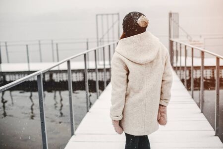 young and merry girl standing in the winter parkの写真素材