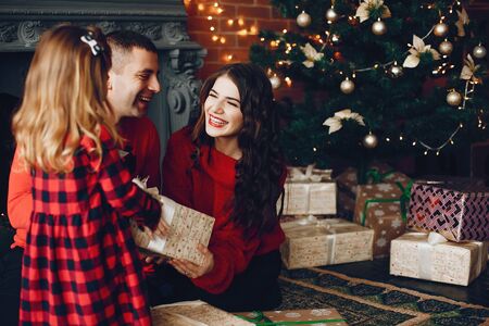 Family sitting at home near christmas treeの販売画像