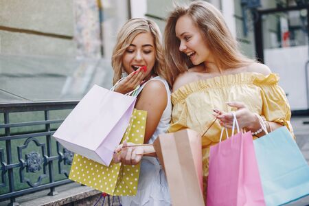 Cute girls with shopping bag in a cityの写真素材