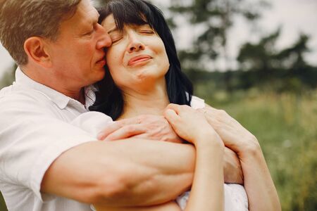Beautiful adult couple spend time in a summer fieldの写真素材