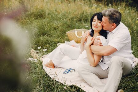 Beautiful adult couple spend time in a summer fieldの写真素材