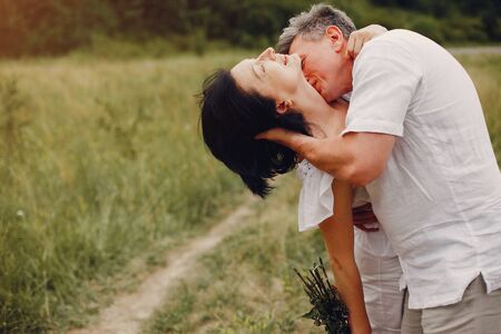 Beautiful adult couple spend time in a summer fieldの写真素材