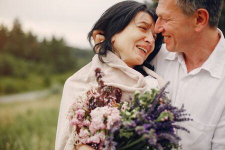 Beautiful adult couple spend time in a summer fieldの写真素材