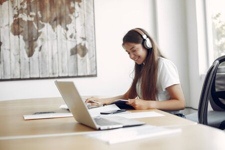 Young student sitting at the table and use the laptop