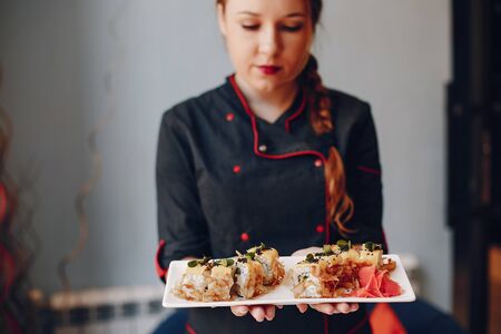 Close-up of person holding sushi in cafeの写真素材