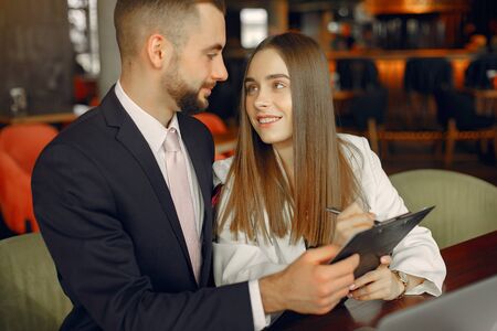 Partners sitting at the table and working in a cafeの写真素材