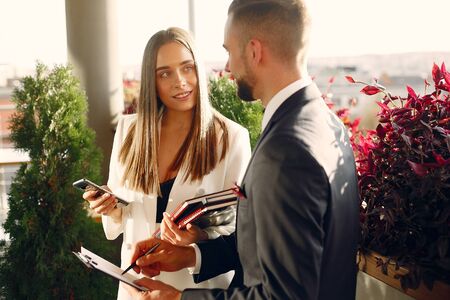 Handsome businessman with wonan standing and working in a cafeの写真素材
