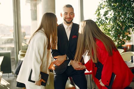 Handsome businessman with women standing and working in a cafeの写真素材