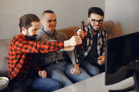 Group of fans are watching a soccer moment on the TV