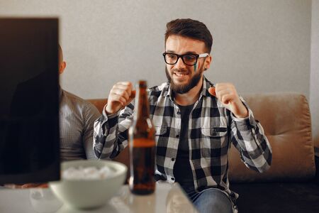 Group of fans are watching a soccer moment on the TVの写真素材