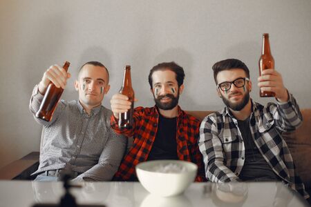 Group of fans are watching a soccer moment on the TVの写真素材