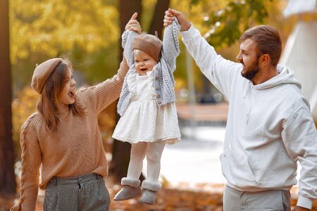 Family with little daughter in a autumn parkの写真素材