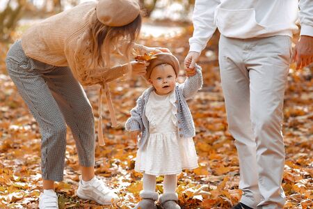 Family with little daughter in a autumn parkの写真素材