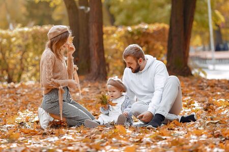 Family with little daughter in a autumn parkの写真素材