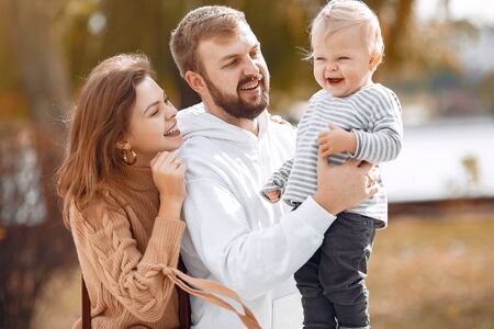 Family with little daughter in a autumn parkの写真素材