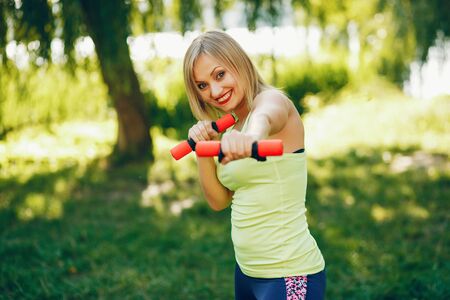 A beautiful girl is engaged in morning exercise in the park.の写真素材