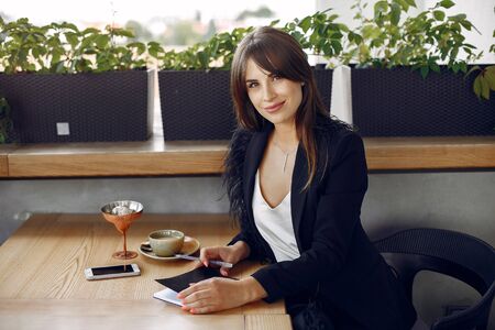 Businesswoman sitting at the table in a cafe and workingの写真素材
