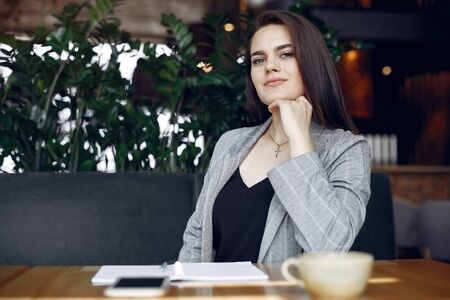 Businesswoman sitting at the table in a cafe and workingの写真素材