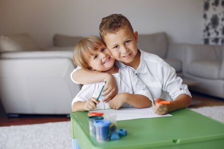 Children siting at the green table and drawingの写真素材