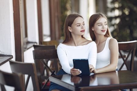 Two elegant and stylish girls in a summer cafeの写真素材