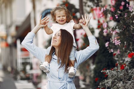 Mother with daughter playing in a summer cityの写真素材