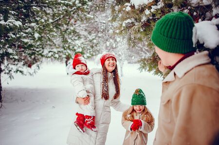 Family with cute daughters in a winter parkの写真素材