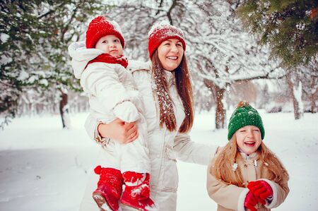 Family with cute daughters in a winter parkの写真素材