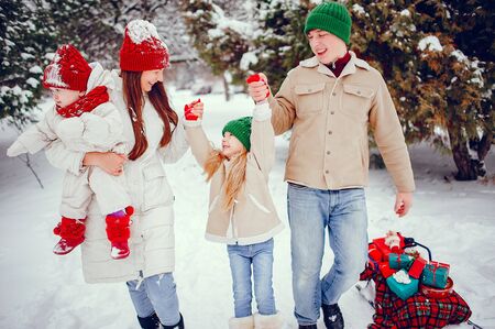 Family with cute daughters in a winter parkの写真素材