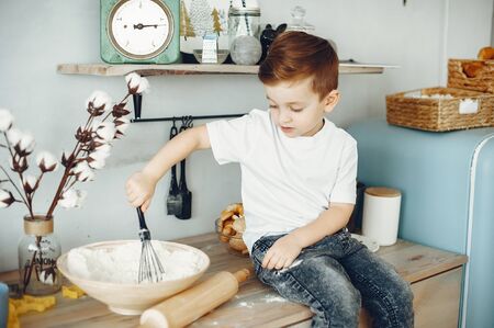 Cute little boy sitting in a kitchenの写真素材