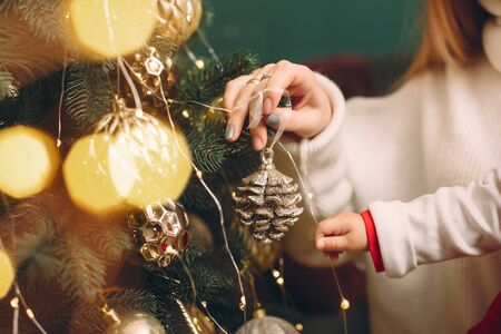 Mother with cute daughter near christmas treeの写真素材