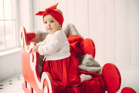Cute little girl sitting in a christmas decorationsの写真素材