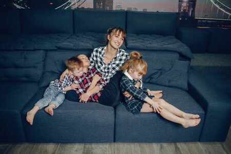 Mother and little children sitting on a couchの写真素材