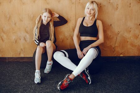 Mother and daughter doing yoga in a yoga studioの写真素材