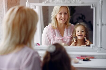 Mother and daughter gather in the morning in front of a mirrorの写真素材