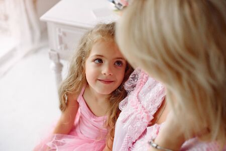 Mother and daughter gather in the morning near mirrorの写真素材