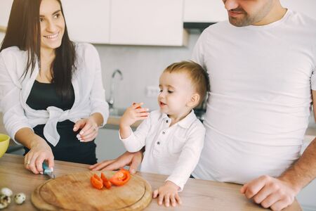 Family prepare the salad in a kitchenの写真素材