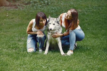 Two girls in a spring park playing with cute dog