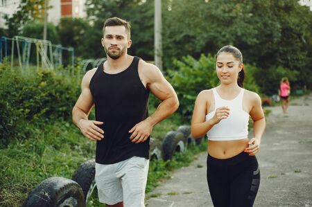 Beautiful couple training in a summer park