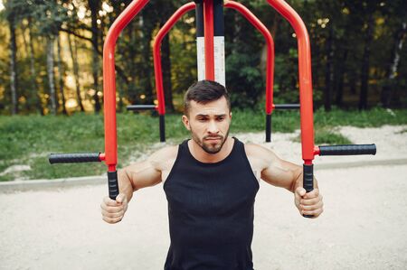 Handsome man training in a summer parkの写真素材
