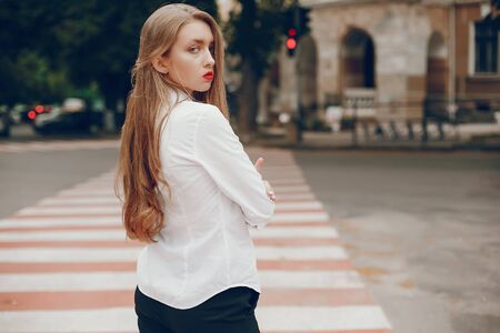 Stylish gir standing in a summer cityの写真素材