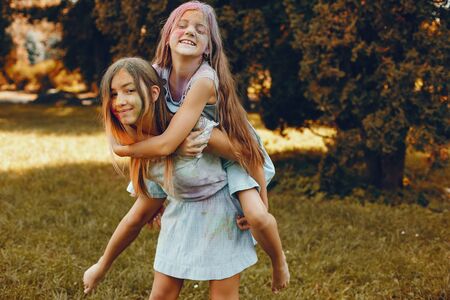 Two cute girls have fun in a summer parkの写真素材