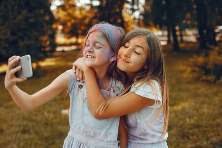 Two cute girls have fun in a summer parkの写真素材