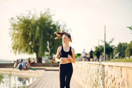 Beautiful sports girl in a summer parkの写真素材